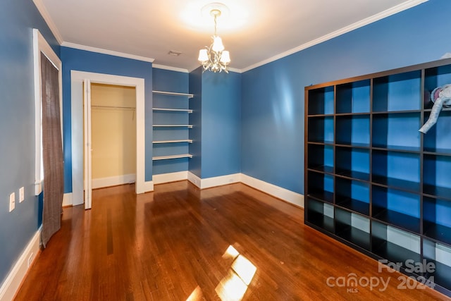 interior space with ornamental molding, wood-type flooring, a chandelier, and a closet