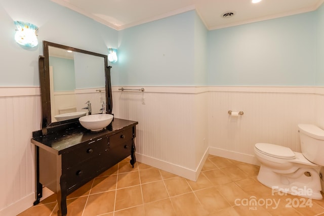 bathroom featuring tile patterned flooring, toilet, crown molding, and vanity