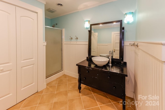 bathroom with a shower with door, vanity, and tile patterned flooring