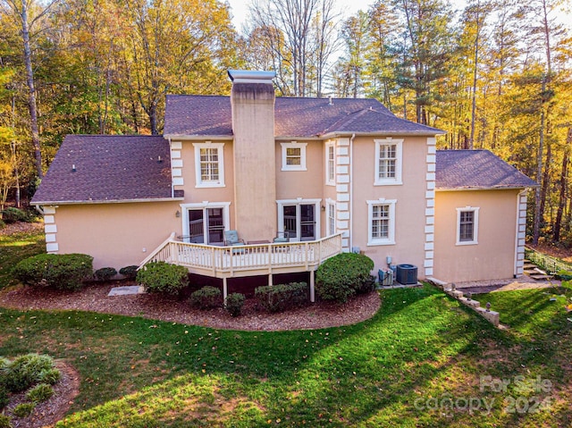 back of property featuring central air condition unit, a yard, and a wooden deck