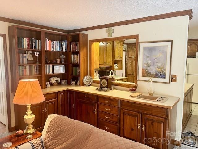 bar with white fridge, crown molding, a textured ceiling, sink, and tile patterned flooring