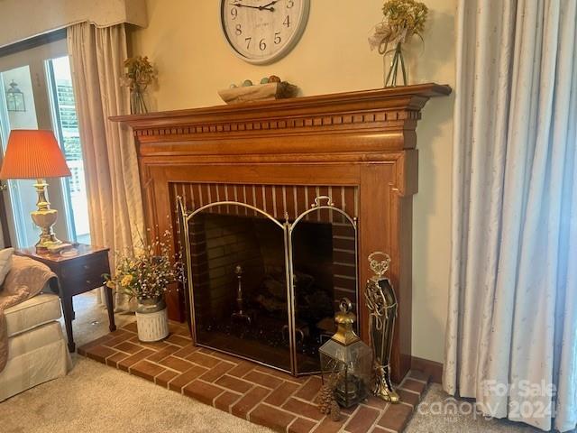 interior details with carpet and a brick fireplace