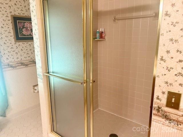 bathroom with a shower with shower door and tile patterned floors