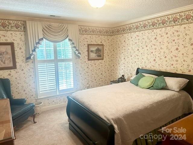 carpeted bedroom featuring a textured ceiling and crown molding