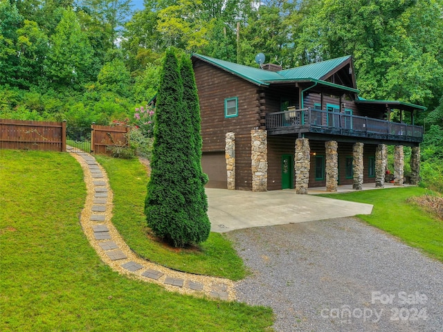 log cabin with a front yard and a garage