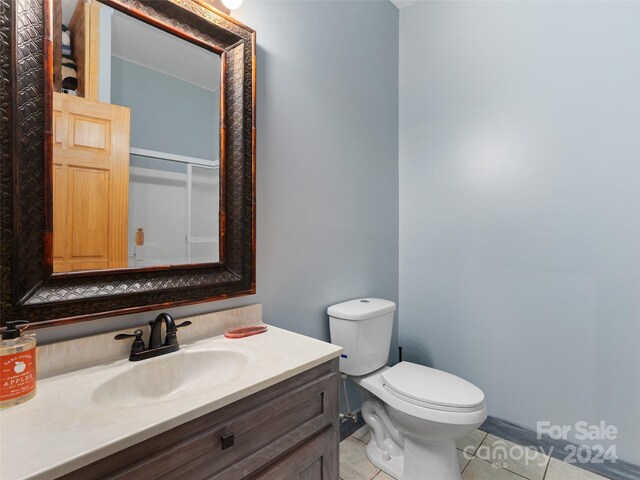 bathroom featuring toilet, vanity, and tile patterned floors