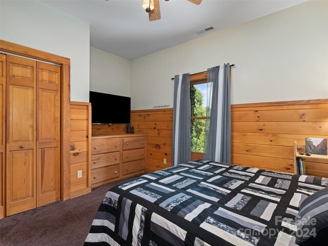 bedroom featuring ceiling fan, a closet, and dark colored carpet