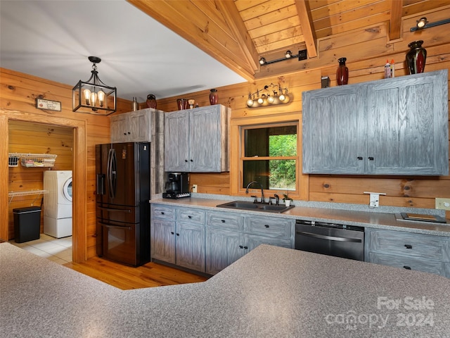 kitchen featuring sink, black refrigerator, lofted ceiling with beams, stainless steel dishwasher, and washer / dryer