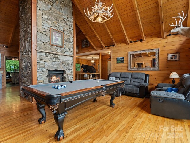 recreation room with wood walls, a fireplace, light wood-type flooring, and billiards