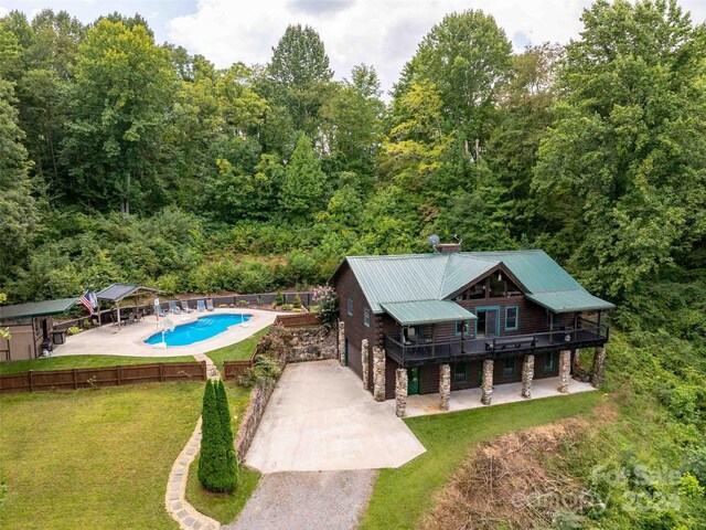 view of swimming pool featuring a lawn, a deck, and a patio