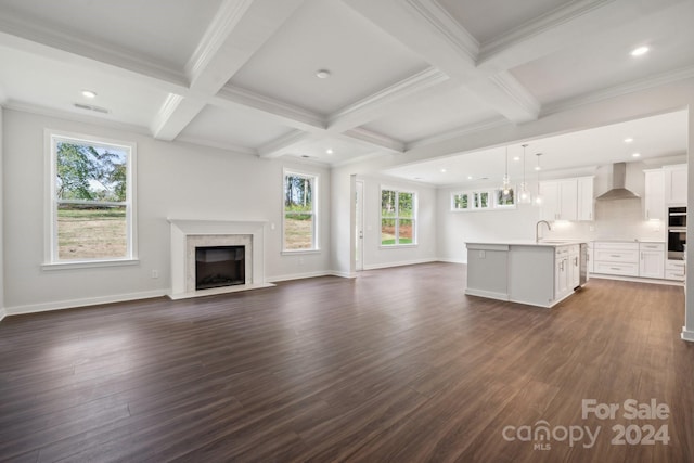 unfurnished living room with dark wood-style flooring, coffered ceiling, a high end fireplace, baseboards, and beamed ceiling