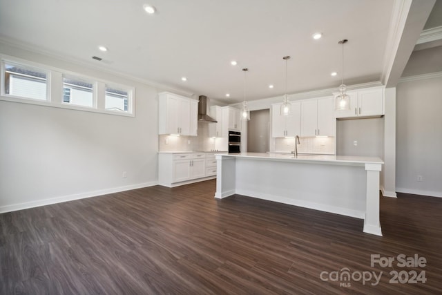 kitchen featuring wall chimney exhaust hood, ornamental molding, light countertops, and tasteful backsplash