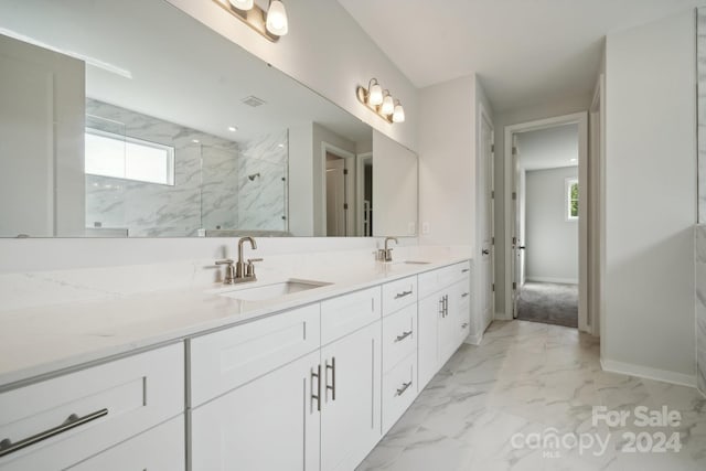 full bathroom with a healthy amount of sunlight, marble finish floor, a marble finish shower, and a sink