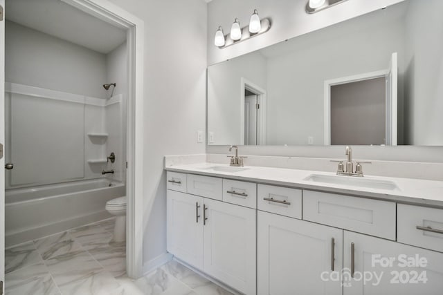 bathroom featuring marble finish floor, double vanity, a sink, and toilet