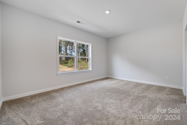 carpeted empty room with visible vents and baseboards