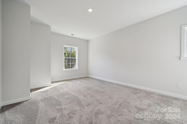 unfurnished room with recessed lighting, carpet flooring, visible vents, and baseboards