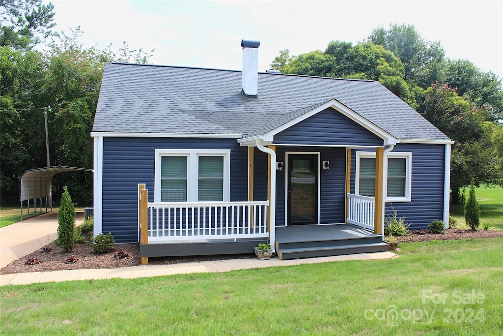 view of front of house featuring a front lawn and a carport