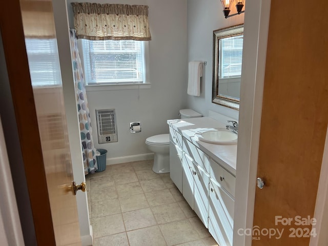 bathroom featuring vanity, a healthy amount of sunlight, toilet, and heating unit