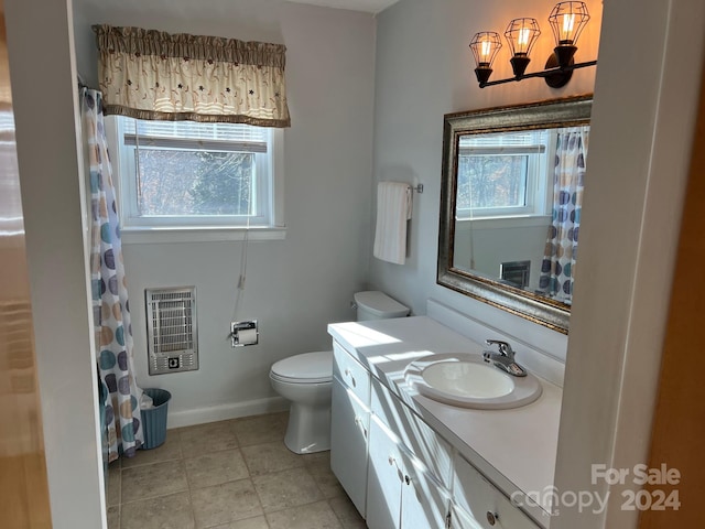 bathroom with vanity, heating unit, and toilet