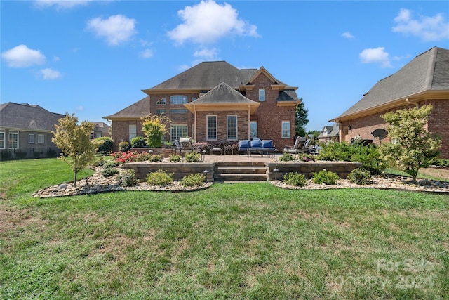 view of front of property featuring a front lawn, a patio, and brick siding