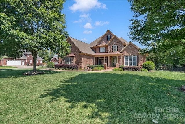 view of front of home featuring brick siding, a front yard, and fence