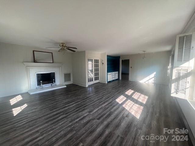 unfurnished living room with dark hardwood / wood-style floors and ceiling fan