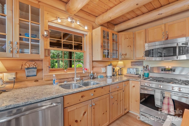 kitchen with light stone counters, sink, wooden ceiling, appliances with stainless steel finishes, and beam ceiling