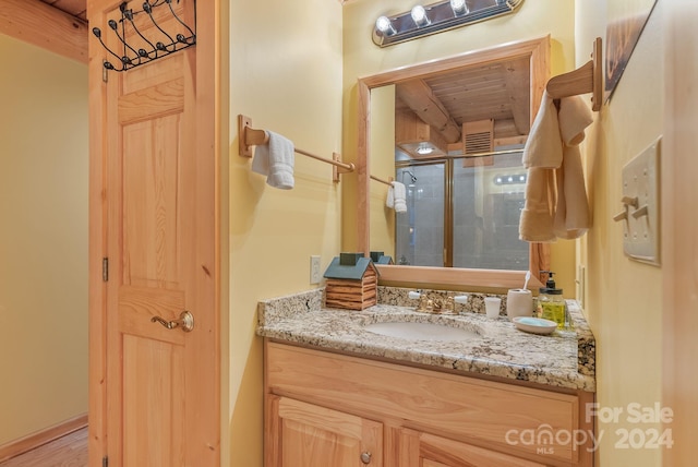 bathroom featuring hardwood / wood-style floors, wood ceiling, a shower with door, and vanity