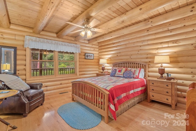 bedroom featuring beamed ceiling, light wood-type flooring, log walls, and wooden ceiling