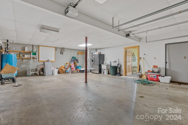 garage featuring a garage door opener and stainless steel fridge