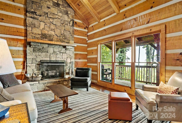 living room with a fireplace, wood ceiling, beamed ceiling, wood walls, and high vaulted ceiling