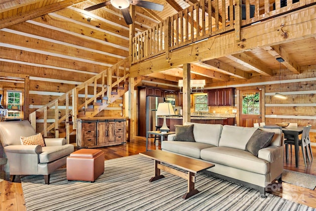 living room with ceiling fan, wood walls, and hardwood / wood-style floors