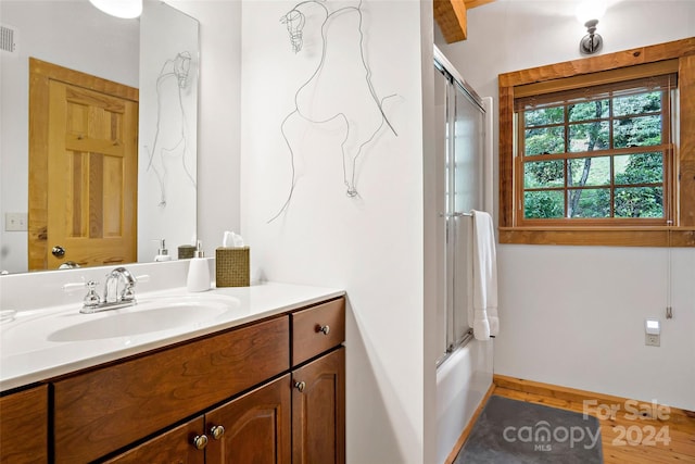 bathroom featuring vanity and bath / shower combo with glass door