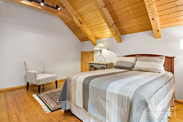 bedroom with wooden ceiling, track lighting, light hardwood / wood-style flooring, and vaulted ceiling with beams