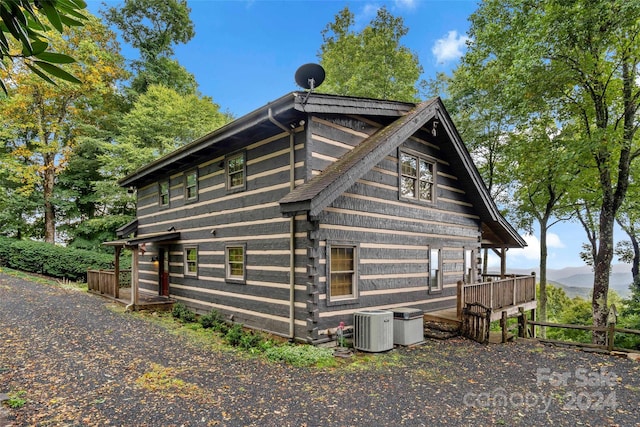 view of side of property featuring cooling unit and a deck with mountain view