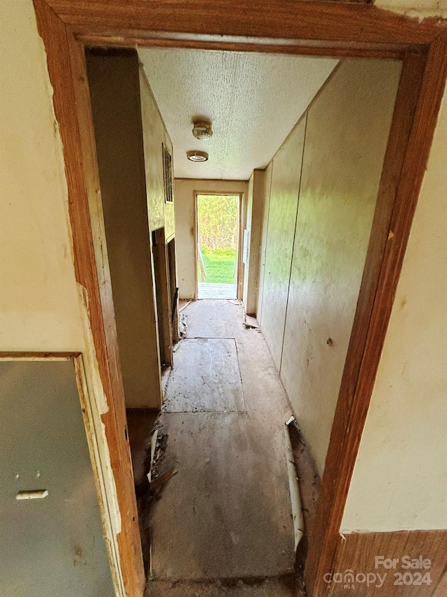 hall featuring a textured ceiling