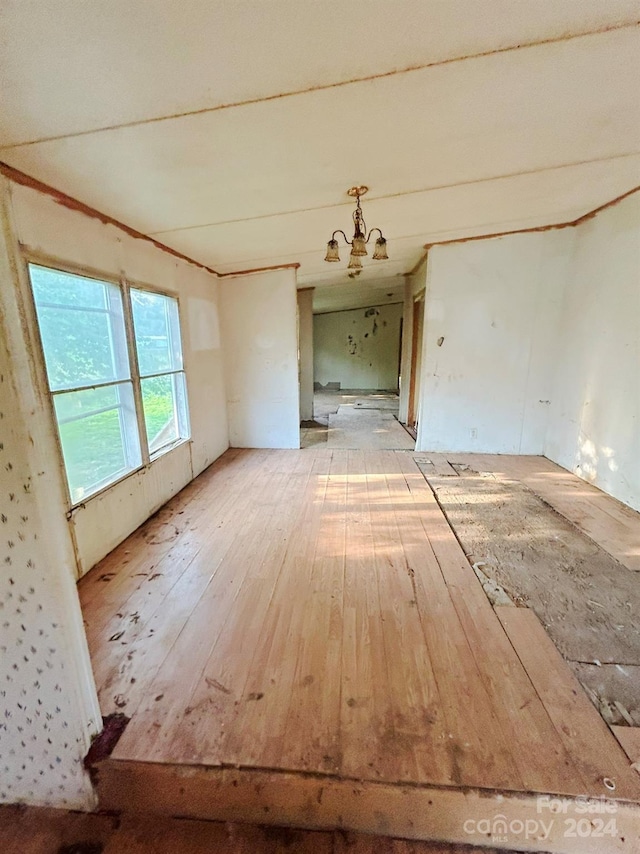 spare room featuring a chandelier and wood-type flooring