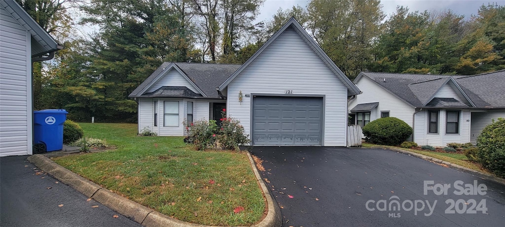 view of front of property featuring a front lawn and a garage