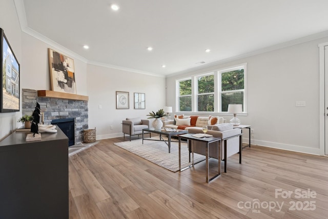 living room featuring crown molding, light hardwood / wood-style floors, and a fireplace