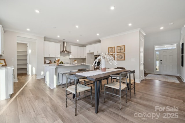 dining space featuring light hardwood / wood-style floors and ornamental molding