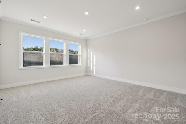 carpeted spare room featuring crown molding