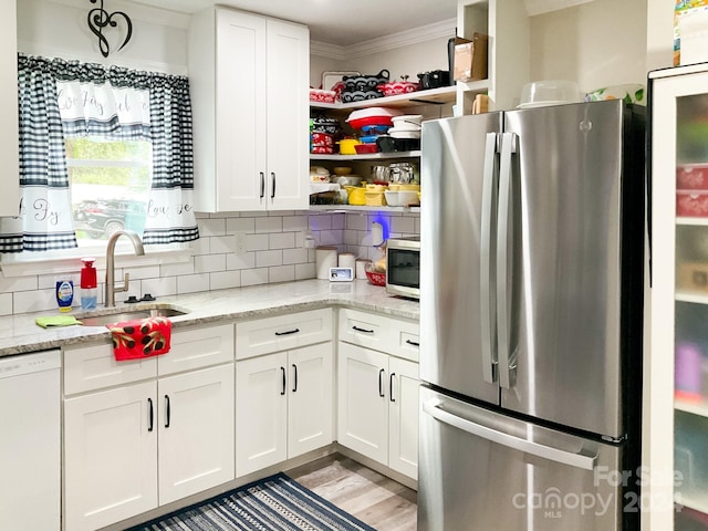 kitchen featuring stainless steel appliances, a sink, open shelves, tasteful backsplash, and crown molding