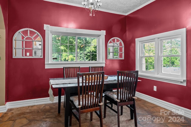 dining space with tile patterned flooring, a notable chandelier, a textured ceiling, and crown molding