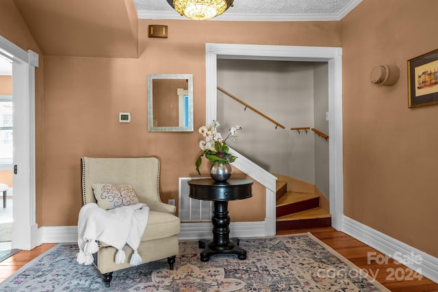 living area featuring hardwood / wood-style flooring and ornamental molding