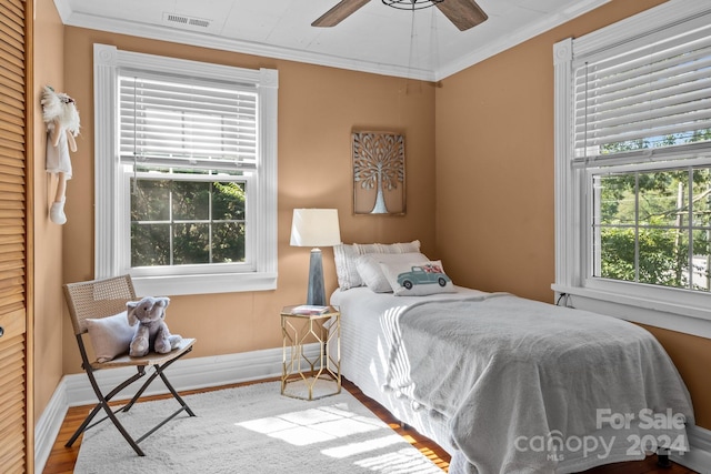 bedroom featuring hardwood / wood-style flooring, crown molding, and ceiling fan