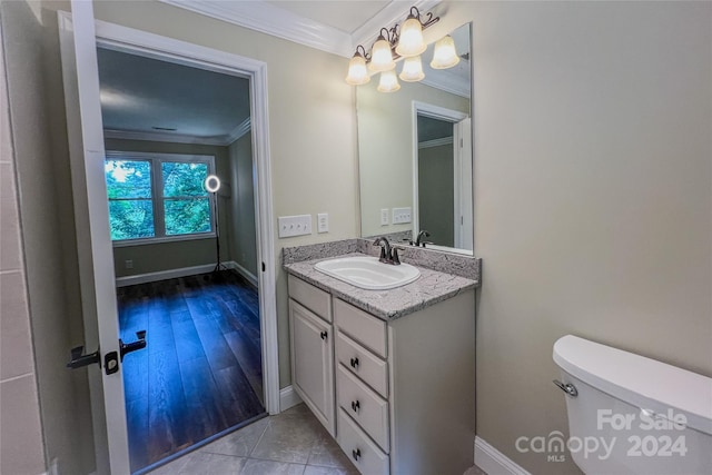 bathroom featuring hardwood / wood-style flooring, crown molding, toilet, and vanity