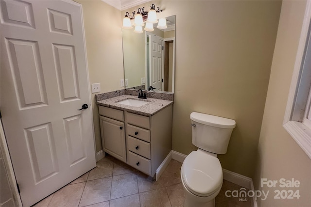 bathroom featuring tile patterned flooring, crown molding, vanity, and toilet