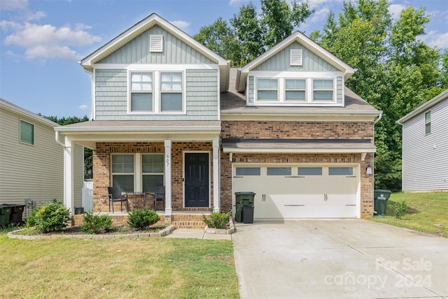 craftsman inspired home featuring a front yard, a garage, and a porch