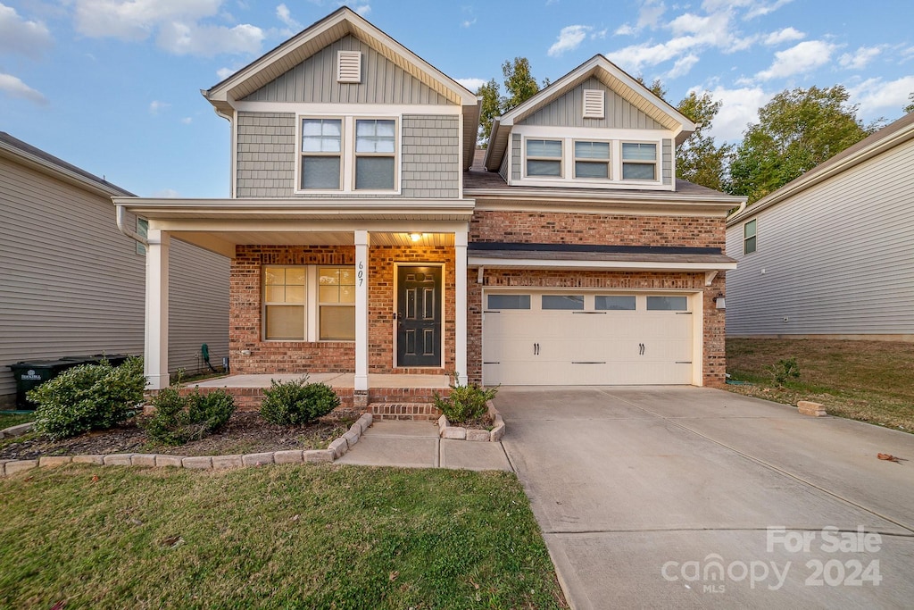 craftsman-style home featuring a front yard, a porch, and a garage