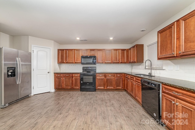 kitchen with light hardwood / wood-style flooring, black appliances, sink, and backsplash